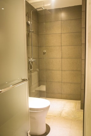 A modern bathroom with a glass-enclosed shower, a white toilet, and tiled walls. - James Joyce Coffetel - Guangzhou Exhibition Center (Guangzhou)