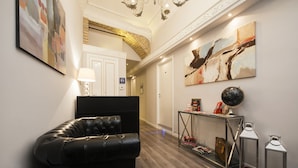 A modern living room with a leather sofa, a glass coffee table, and abstract art on the walls. - Arenula Suites (Rome)