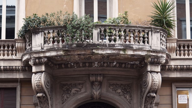 A historic building with ornate iron gates and a balcony with plants. - Arenula Suites (Rome)