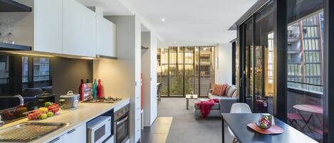 A modern kitchen with a dining area and a view of the city.