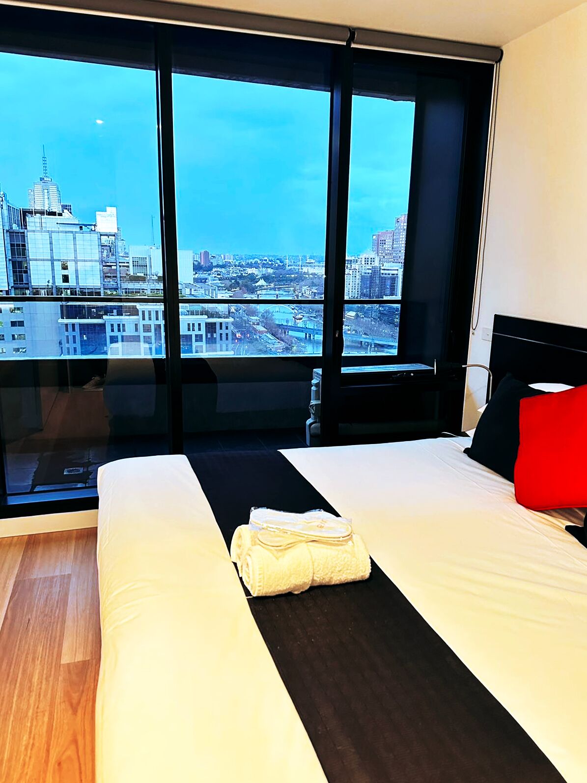 Une chambre d’hôtel dotée d’une grande fenêtre donnant sur la ville.