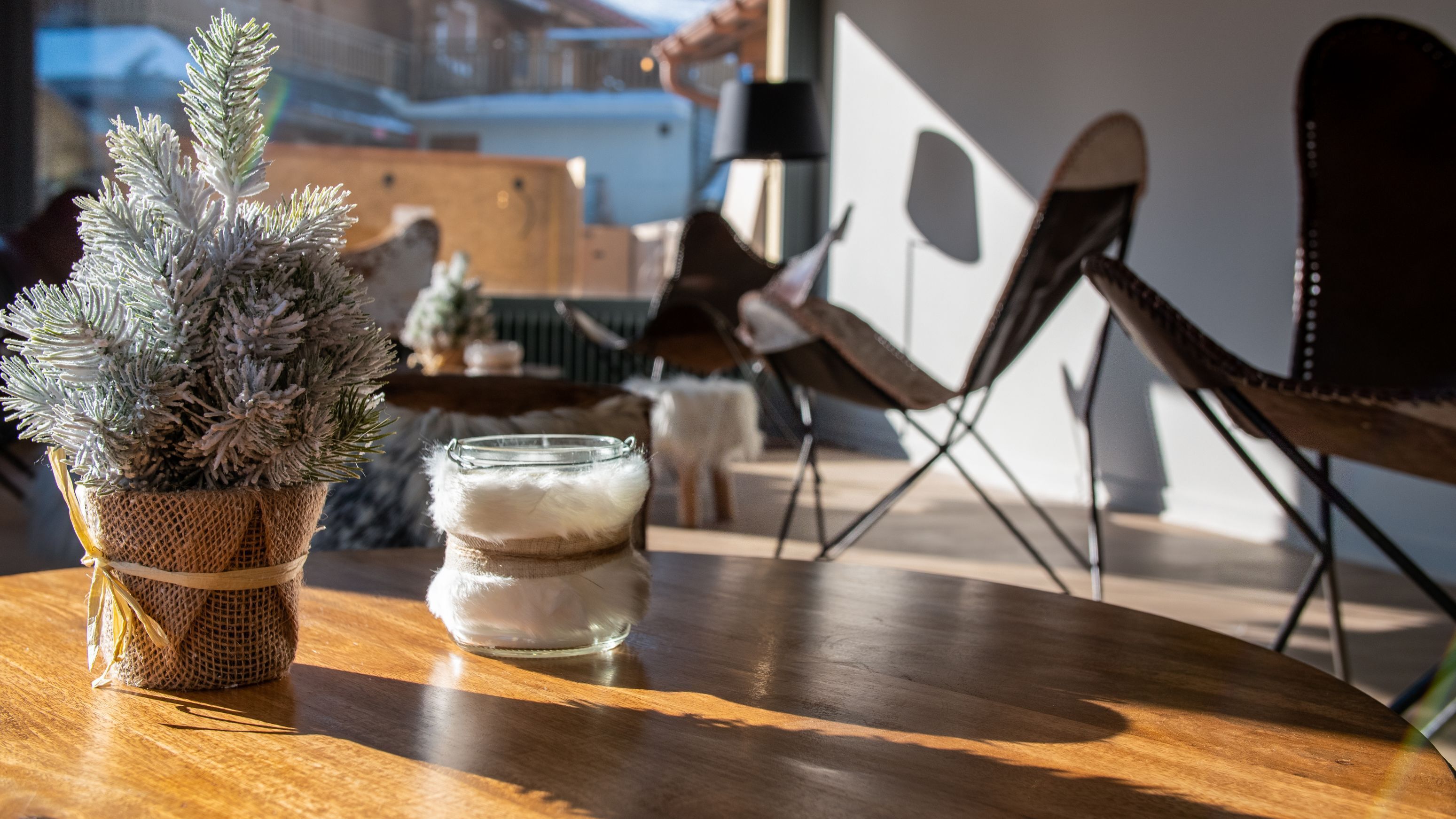A wooden table with a small potted plant and a glass jar with a white lid.