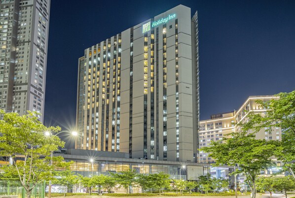 A tall, modern hotel building with a prominent sign for Holiday Inn.