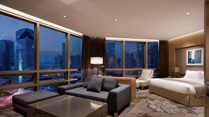 A modern hotel room with a large city view, a sofa, a bed, and a desk. - Holiday Inn Incheon Songdo by IHG (Incheon)