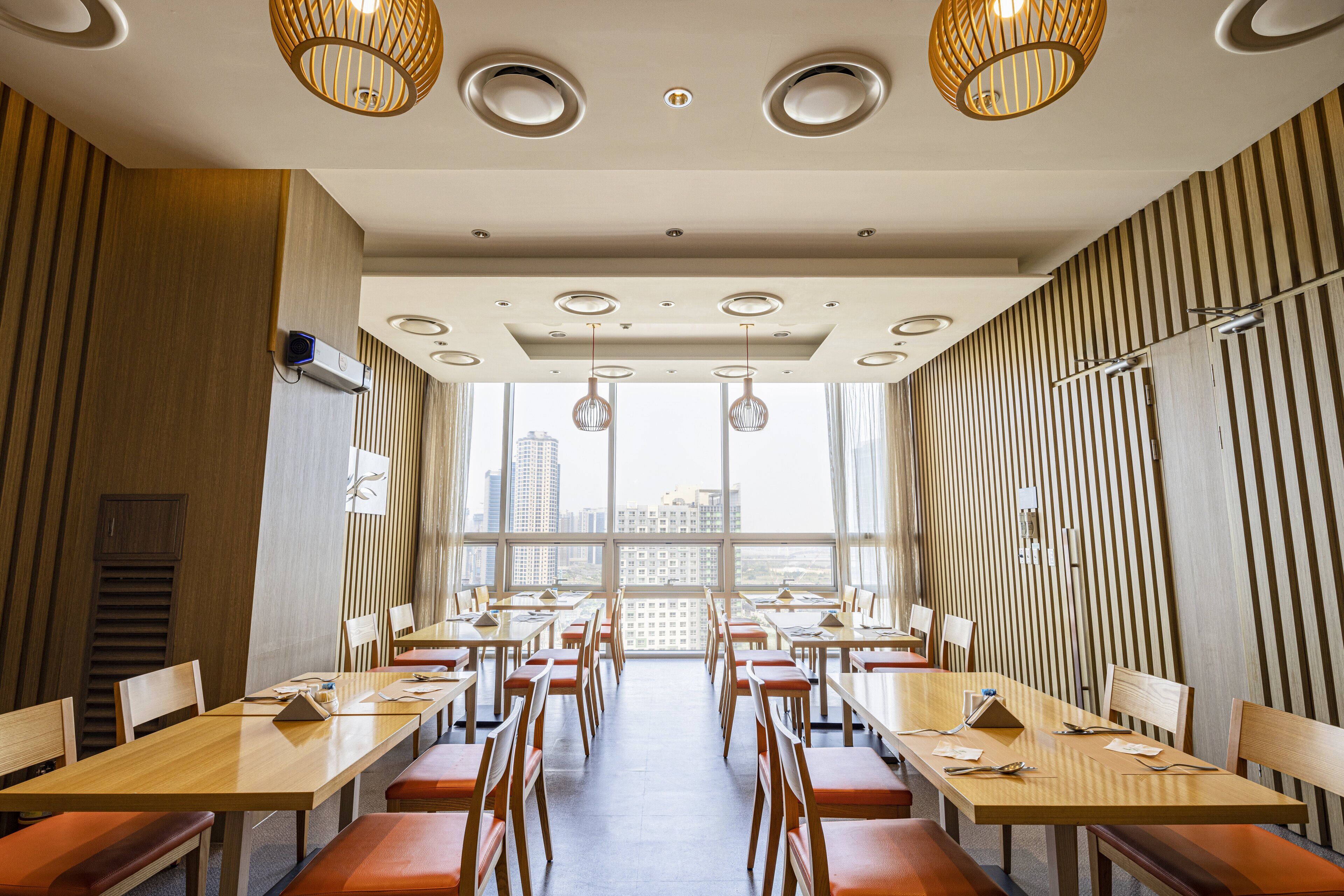 A modern conference room with long tables, chairs, and pendant lighting.