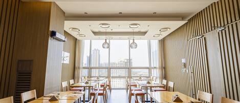 A modern conference room with long tables, chairs, and pendant lighting.