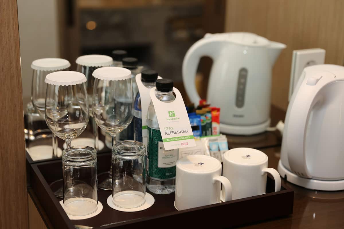 A tray with various glassware and a kettle, likely in a hotel setting.