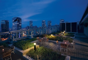 A rooftop terrace with outdoor seating and a city skyline view. - Holiday Inn Incheon Songdo by IHG (Incheon)