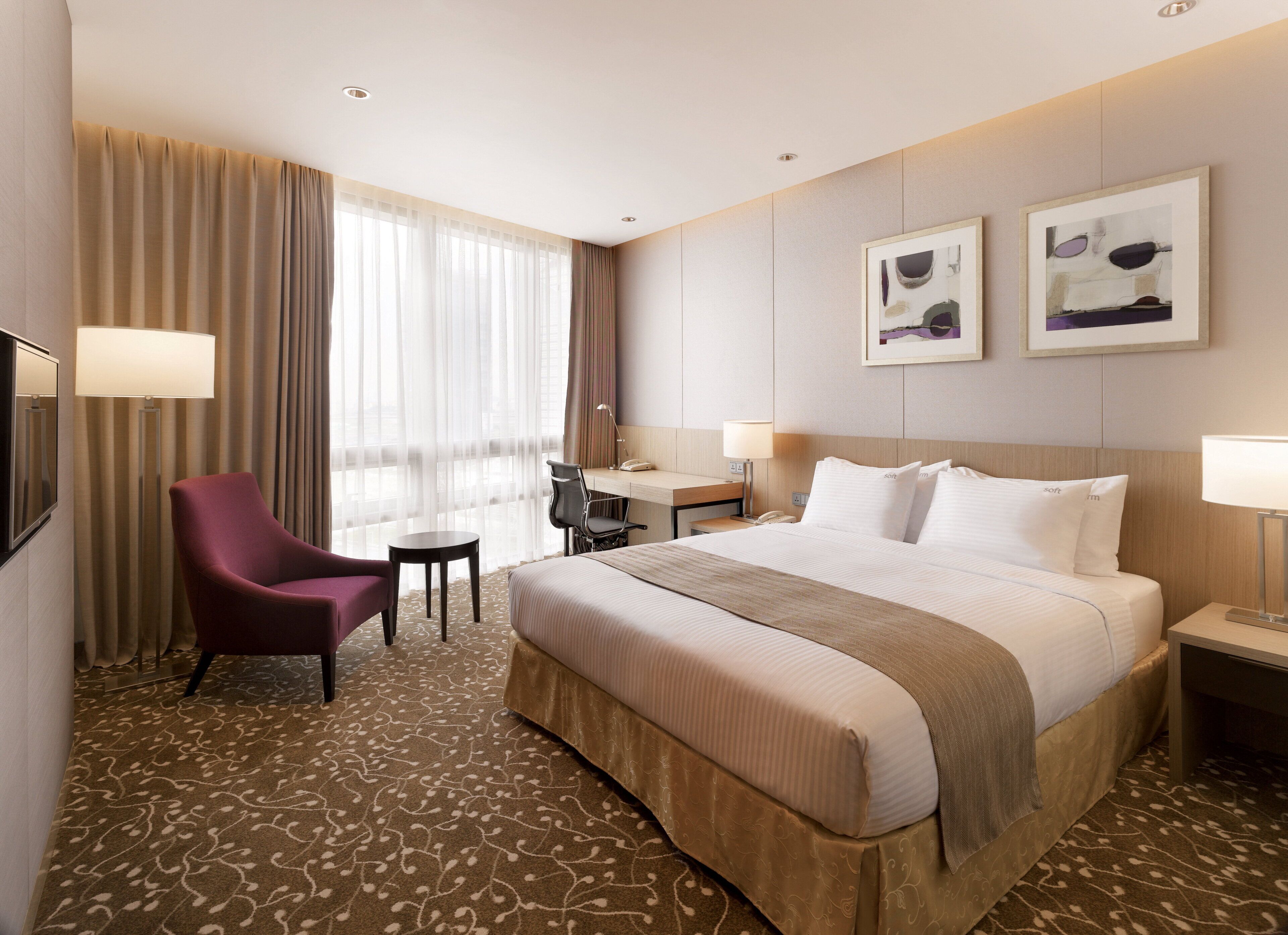 Una habitación de hotel con una cama grande, un escritorio, una silla y un televisor.