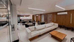 A modern living room with a sofa, coffee table, and dining area. - Royalty Rio Hotel (Rio de Janeiro)