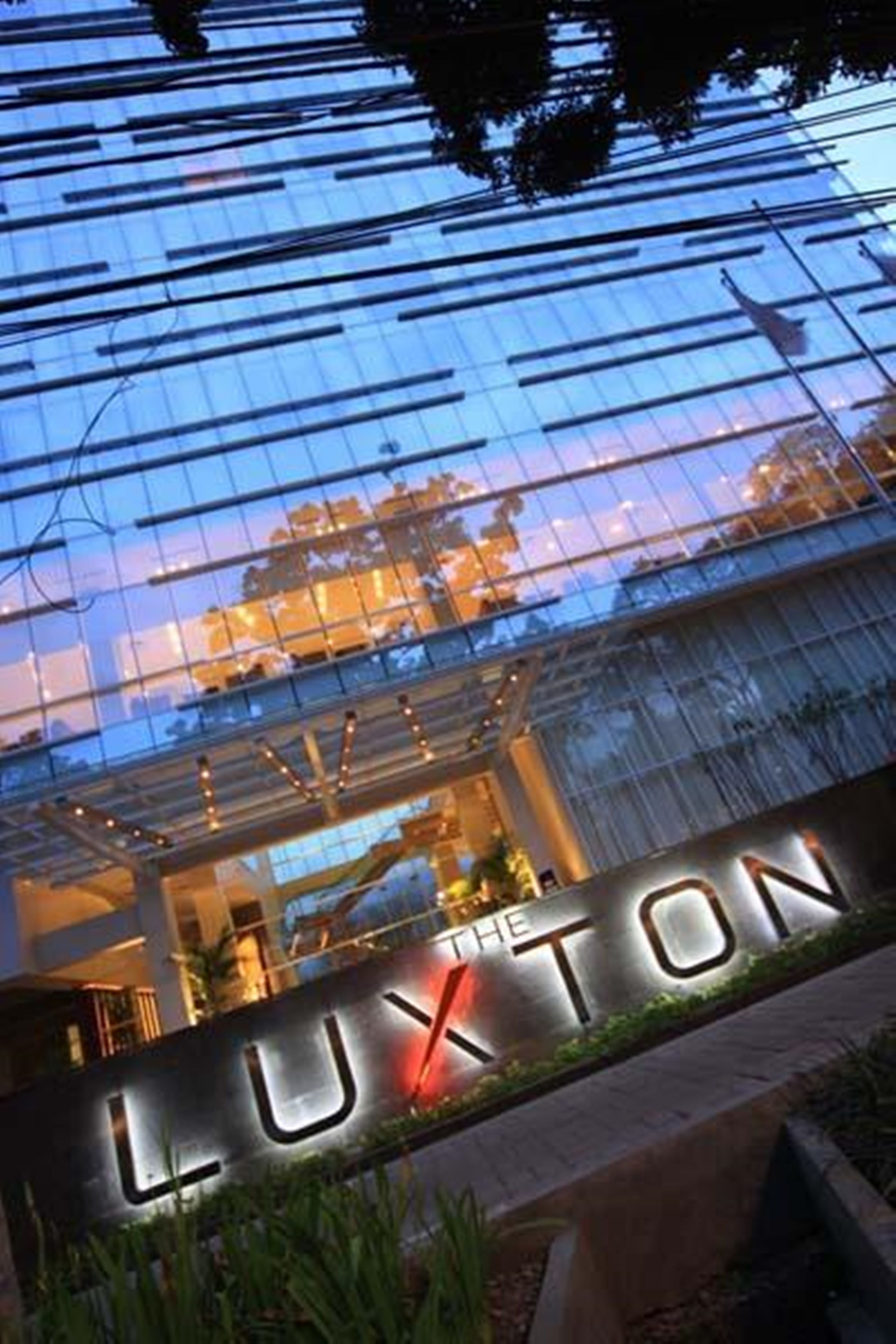 Un edificio moderno con fachada de vidrio reflectante y el nombre 
