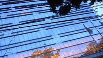 Un edificio moderno con fachada de vidrio reflectante y el nombre