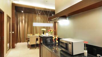 Una cocina moderna con microondas, estufa y comedor con mesa y sillas.