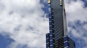 Un immeuble imposant, doté d’une architecture moderne, caractérisé par une série de lignes horizontales et un élément vertical marquant près du sommet.