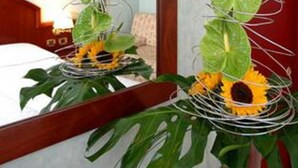 A room with a bed, a mirror, and a decorative plant arrangement. - Venice Palace Hotel (Mirano)
