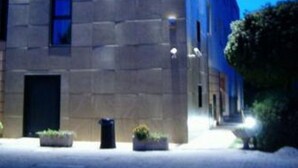 A modern building with a tall, cylindrical structure and a flat roof. - Venice Palace Hotel (Mirano)