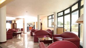 A hotel lobby with red seating, large windows, and a tiled floor. - Venice Palace Hotel (Mirano)