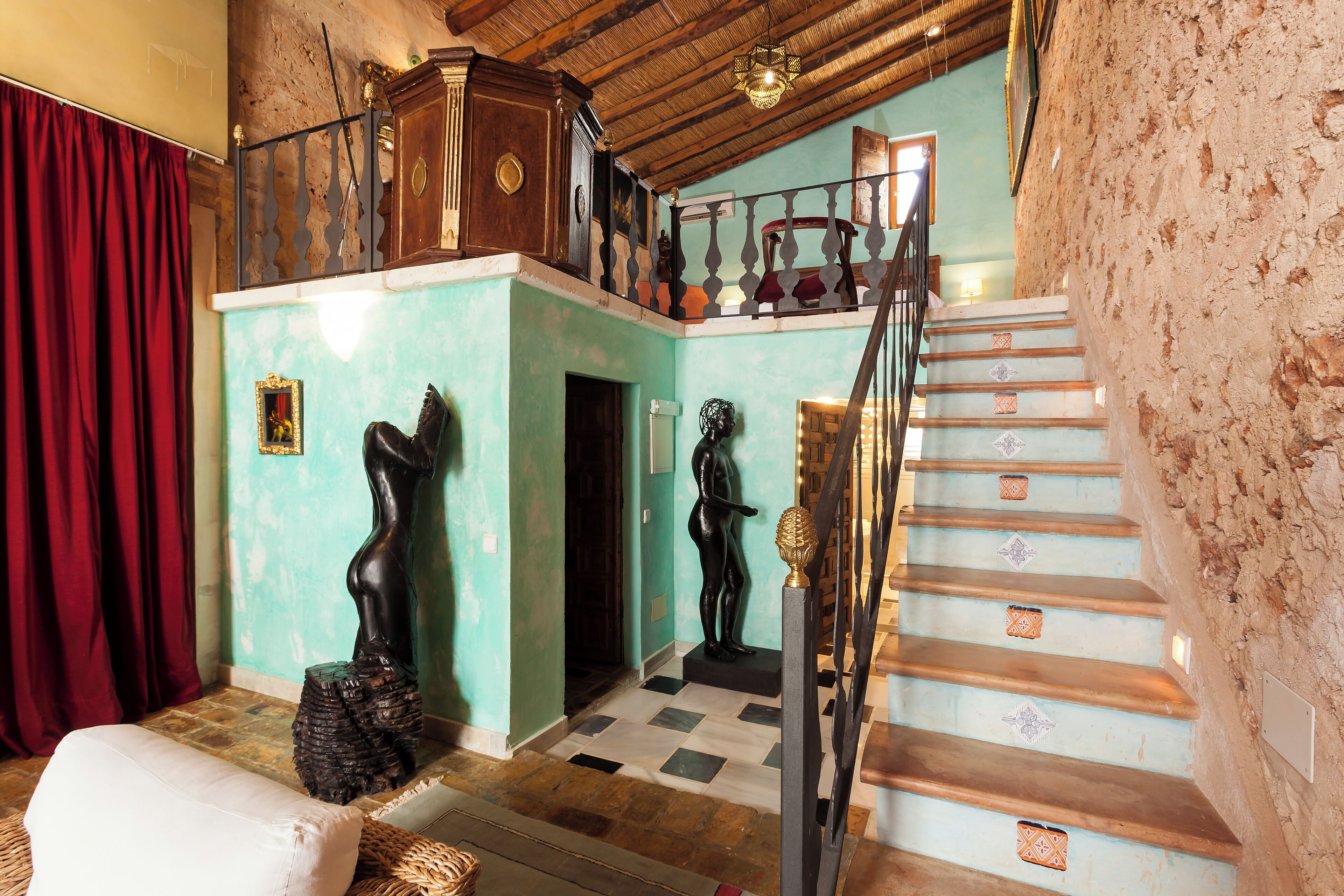 A staircase with patterned steps, a wooden railing, and a red curtain.