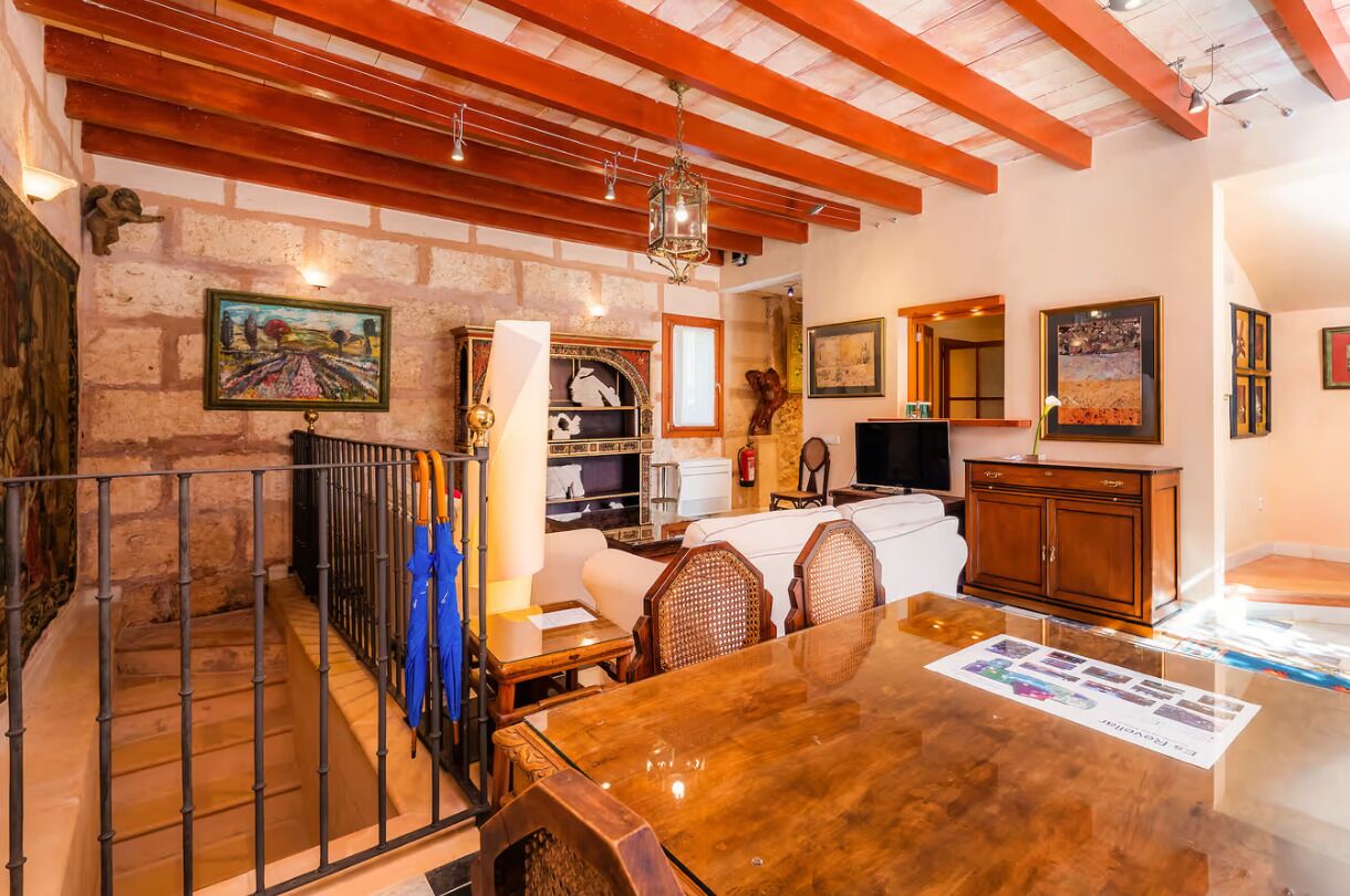 A dining area with a wooden table, chairs, and a fireplace.