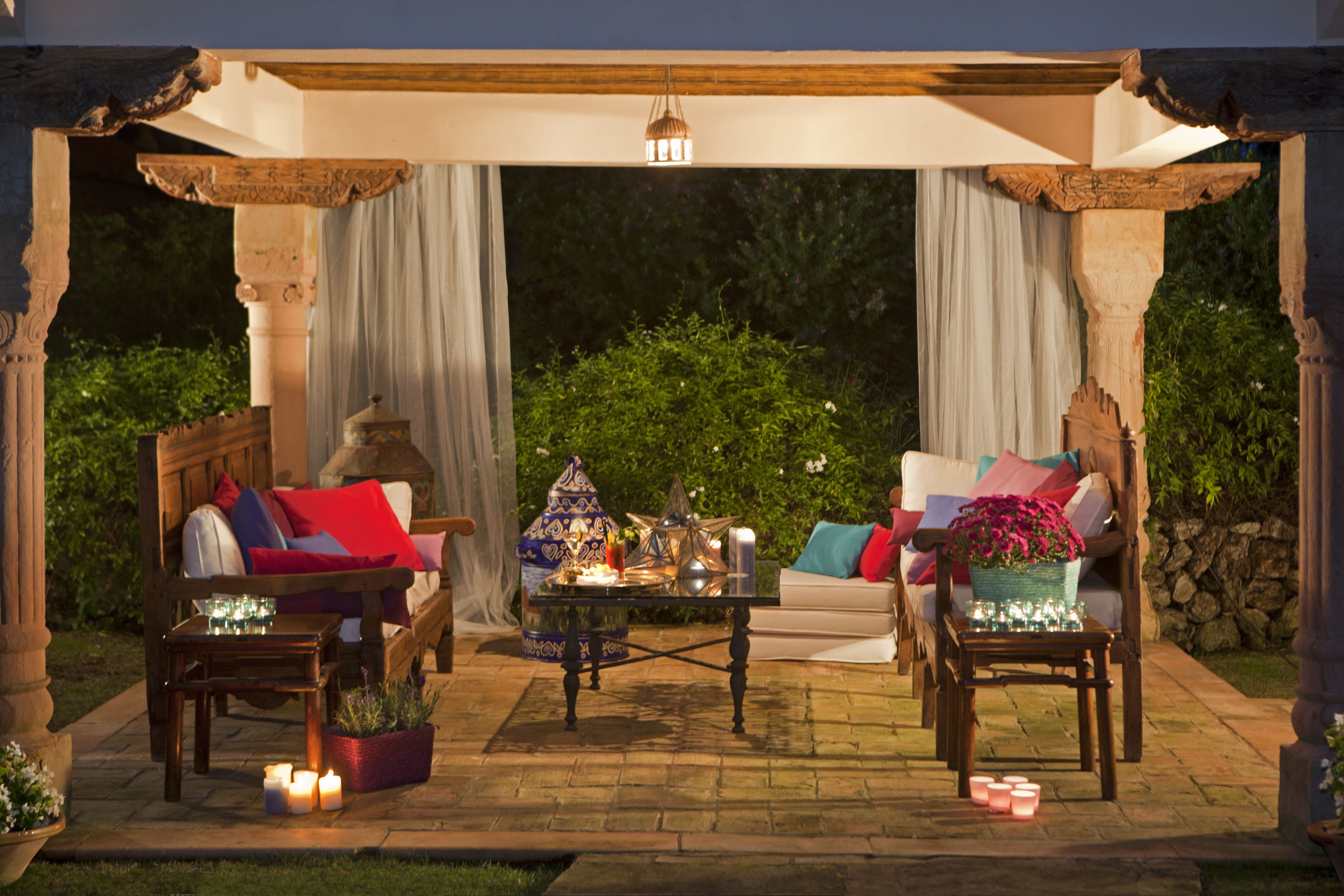 Eine Terrasse im Freien mit zwei Sofas, einem Couchtisch und Kerzen.