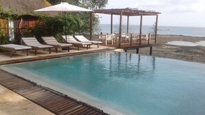 An infinity pool with lounge chairs and a wooden deck overlooking the sea. - Ponta Anchaca (Rubane)