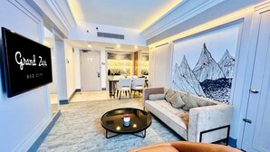 A hotel lobby with a sofa, coffee table, and a dining area with chairs and a table.