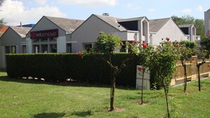 A row of modern buildings with a sign reading "resto novo". - Hôtel Inn Design & Restaurant Amiens (Dury)