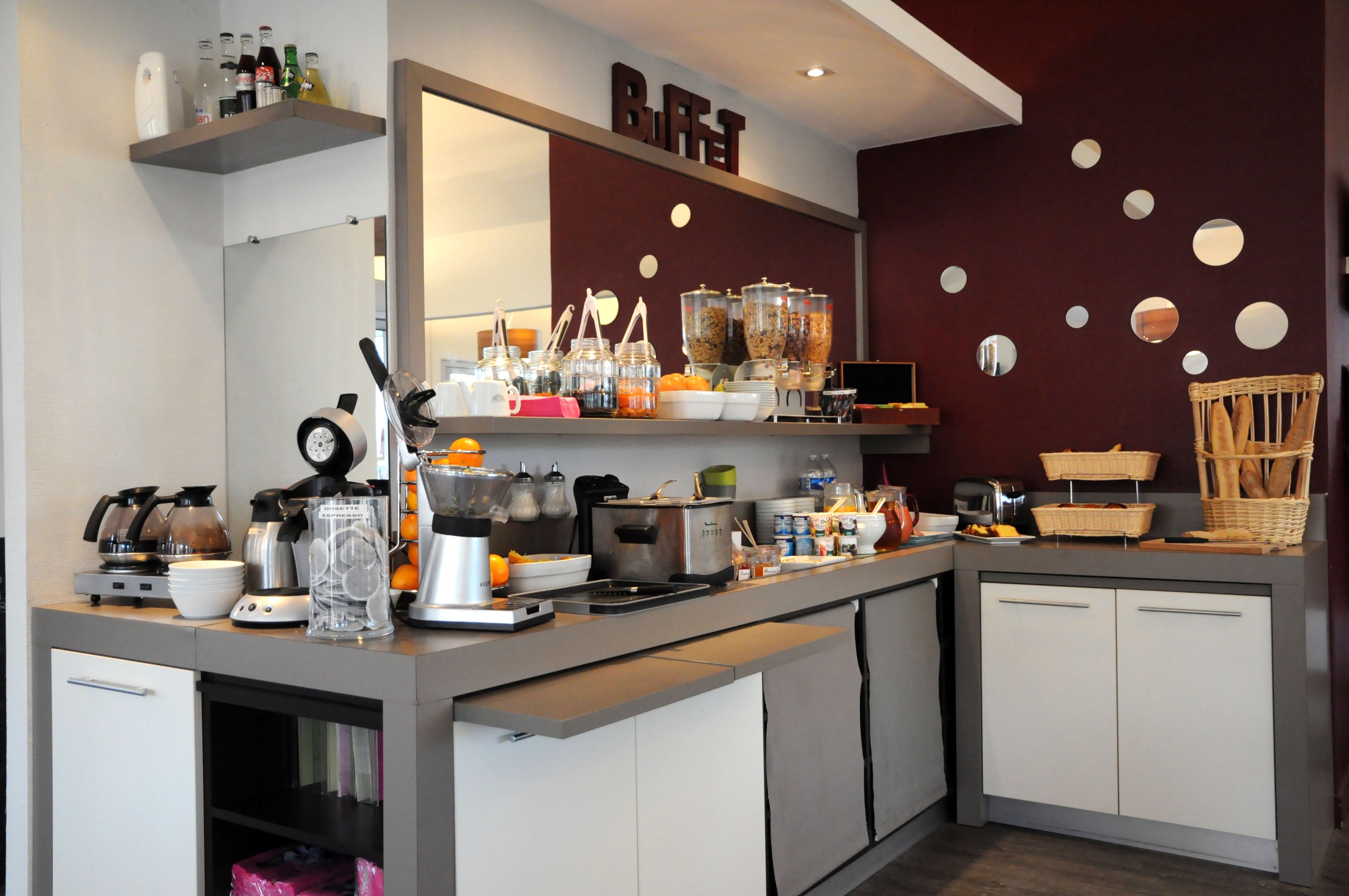 A kitchenette with a coffee machine, blender, and various food containers.