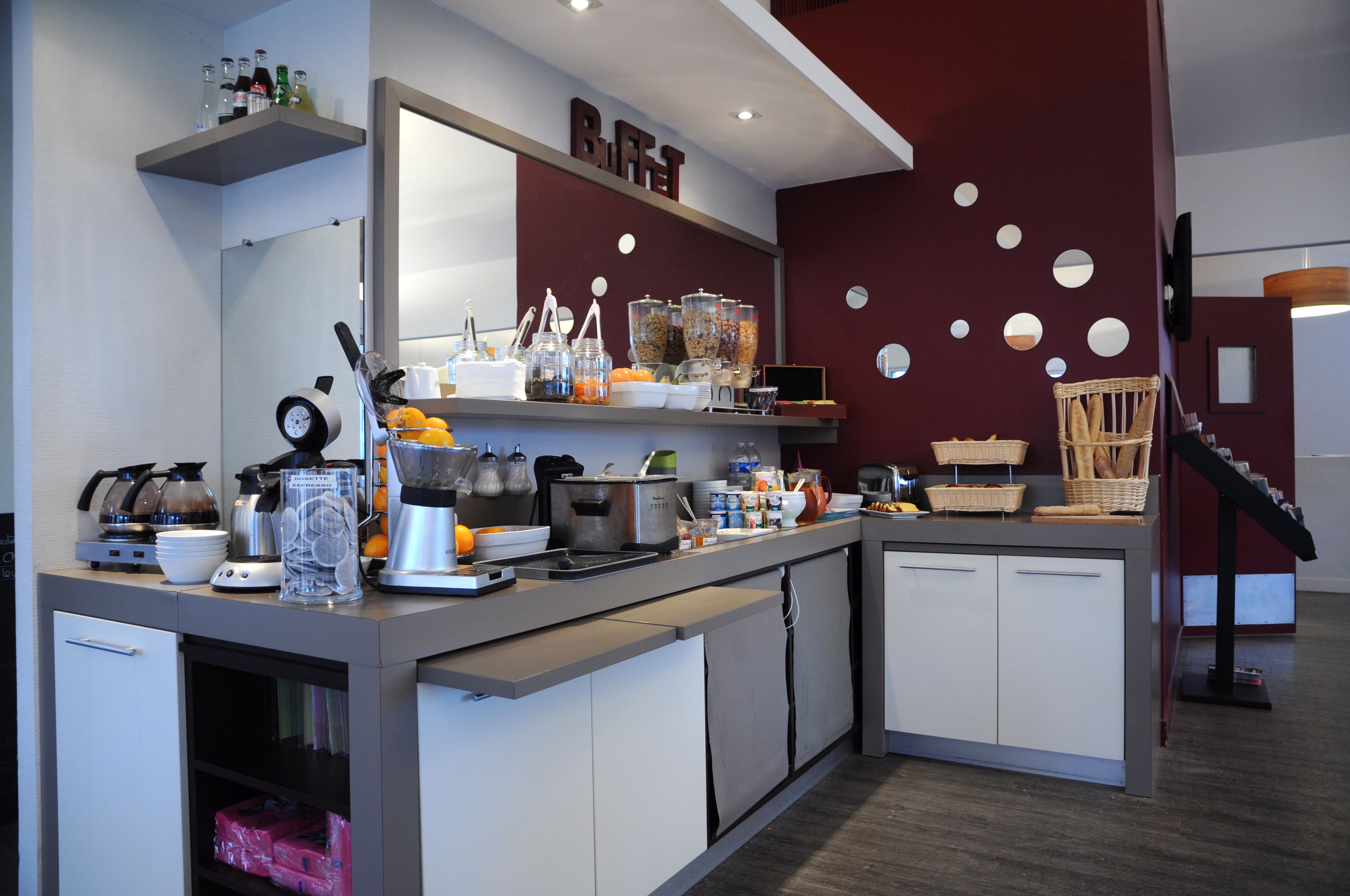 A modern kitchen with a buffet setup, including various food containers and kitchen appliances.