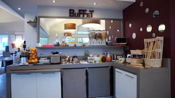 Zona de bufé con mostrador, recipientes de comida y un letrero que dice 'BUFFET'.