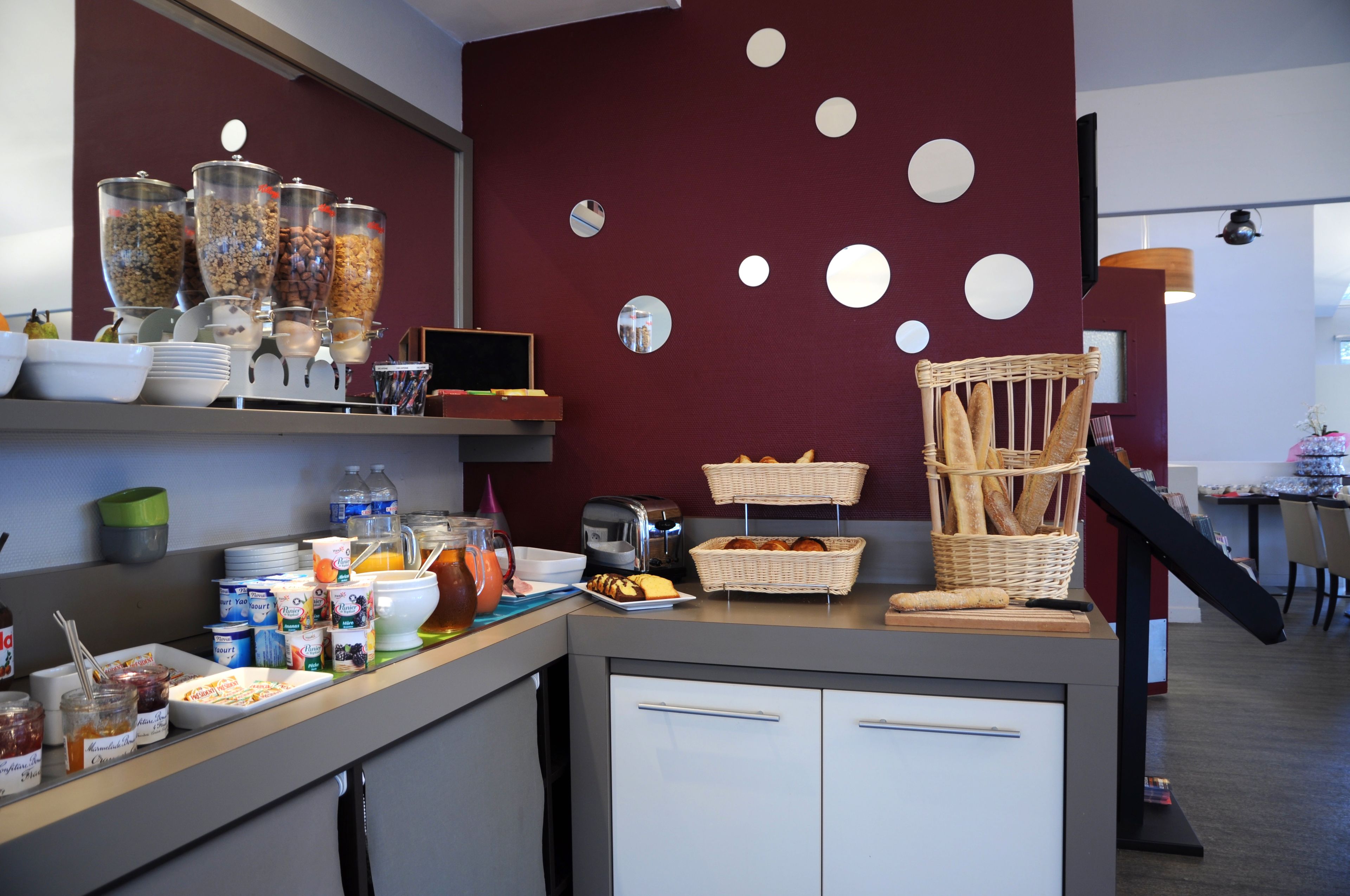 A breakfast buffet with various food items and a wicker basket of bread.