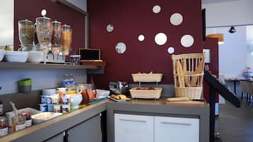 Um buffet de café da manhã com diversos alimentos e uma cesta de pão de vime.