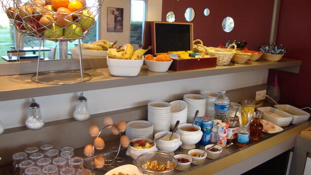 A buffet setup with various food items and utensils. - Hôtel Inn Design & Restaurant Amiens (Dury)