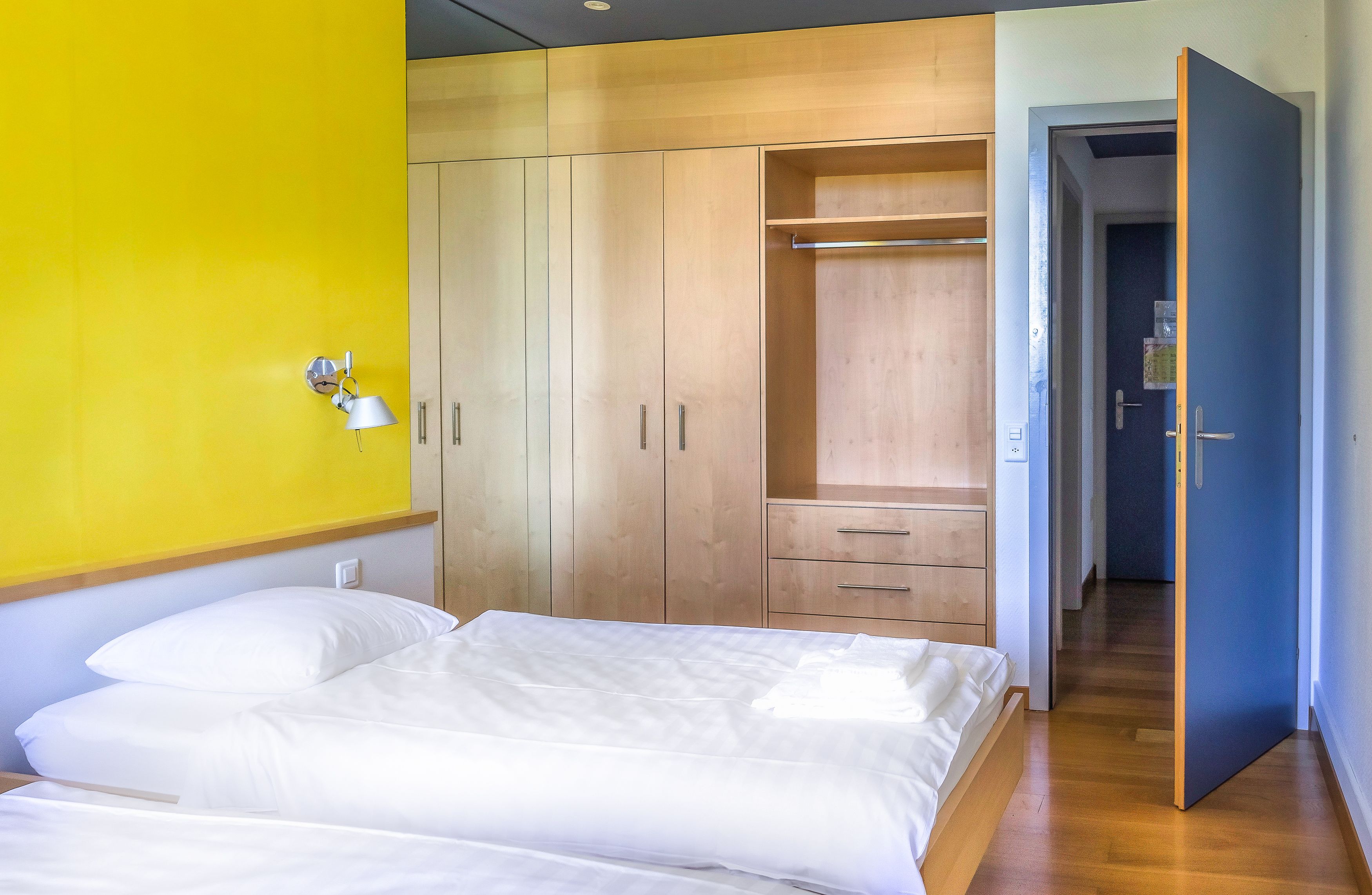 Une chambre à coucher avec un lit, une armoire en bois et un dressing.