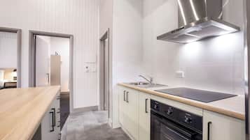 A modern kitchen with a wooden countertop, stainless steel sink, and built-in oven.