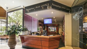 A reception area with a reception desk, a television screen, and a sign for the Nightcap Hotel. - Nightcap at Matthew Flinders Hotel (Chadstone)