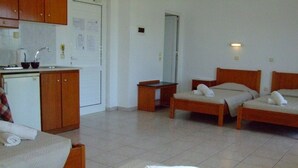 A hotel room with two beds, a small kitchenette, and a bathroom. - Millenium Studios (Rhodes)