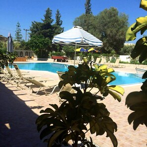 Relax by the serene pool surrounded by lush greenery and comfortable lounge chairs.