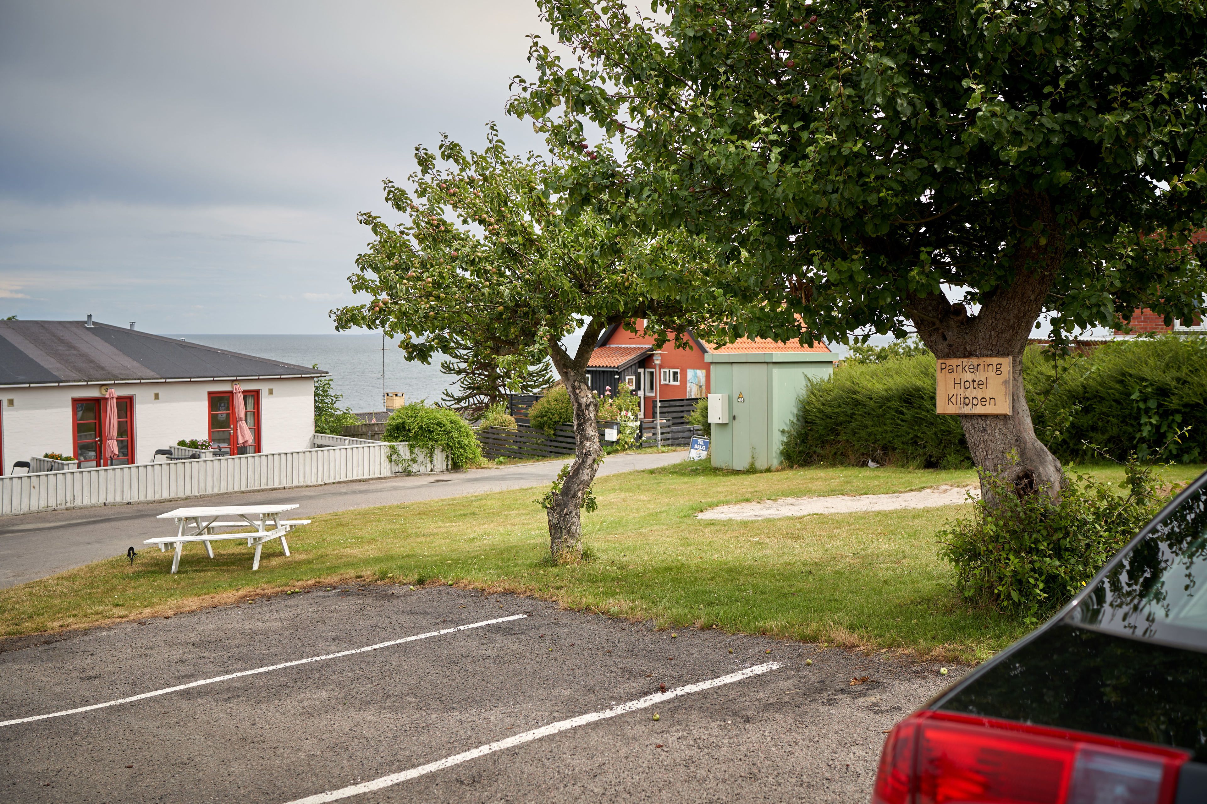 A parking area with a picnic table and a sign for 'Parkerig Hotel Klippen'.