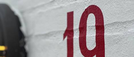 A close-up of a white wall with the number '19' painted in red.