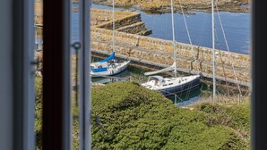 A view of a harbor with boats docked, a stone breakwater, and a clear sky. - Hotel Klippen  (Gudhjem)
