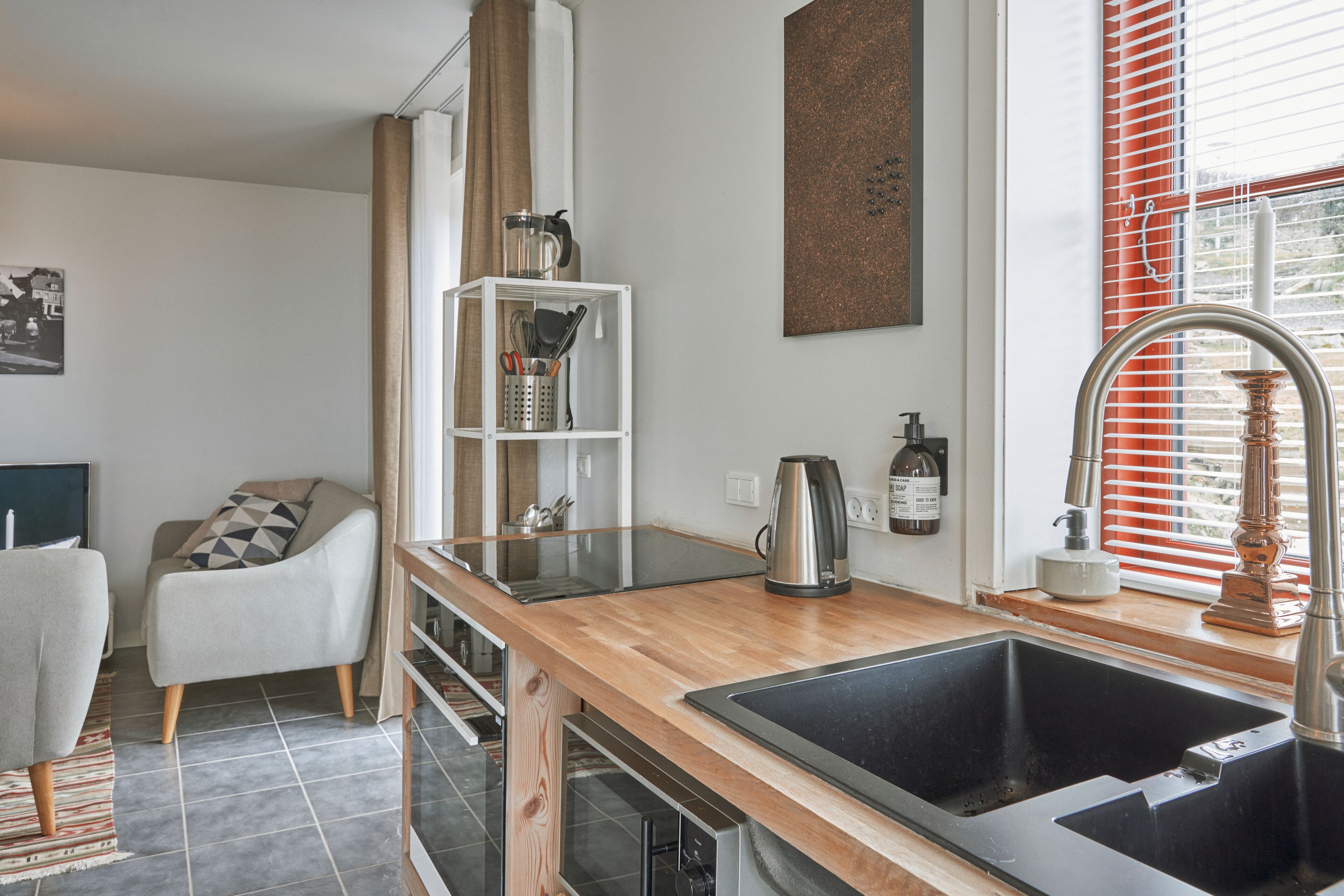 Eine moderne Küche mit einer Holz Arbeitsplatte, einem Edelstahlspülbecken und einem eingebauten Ofen.