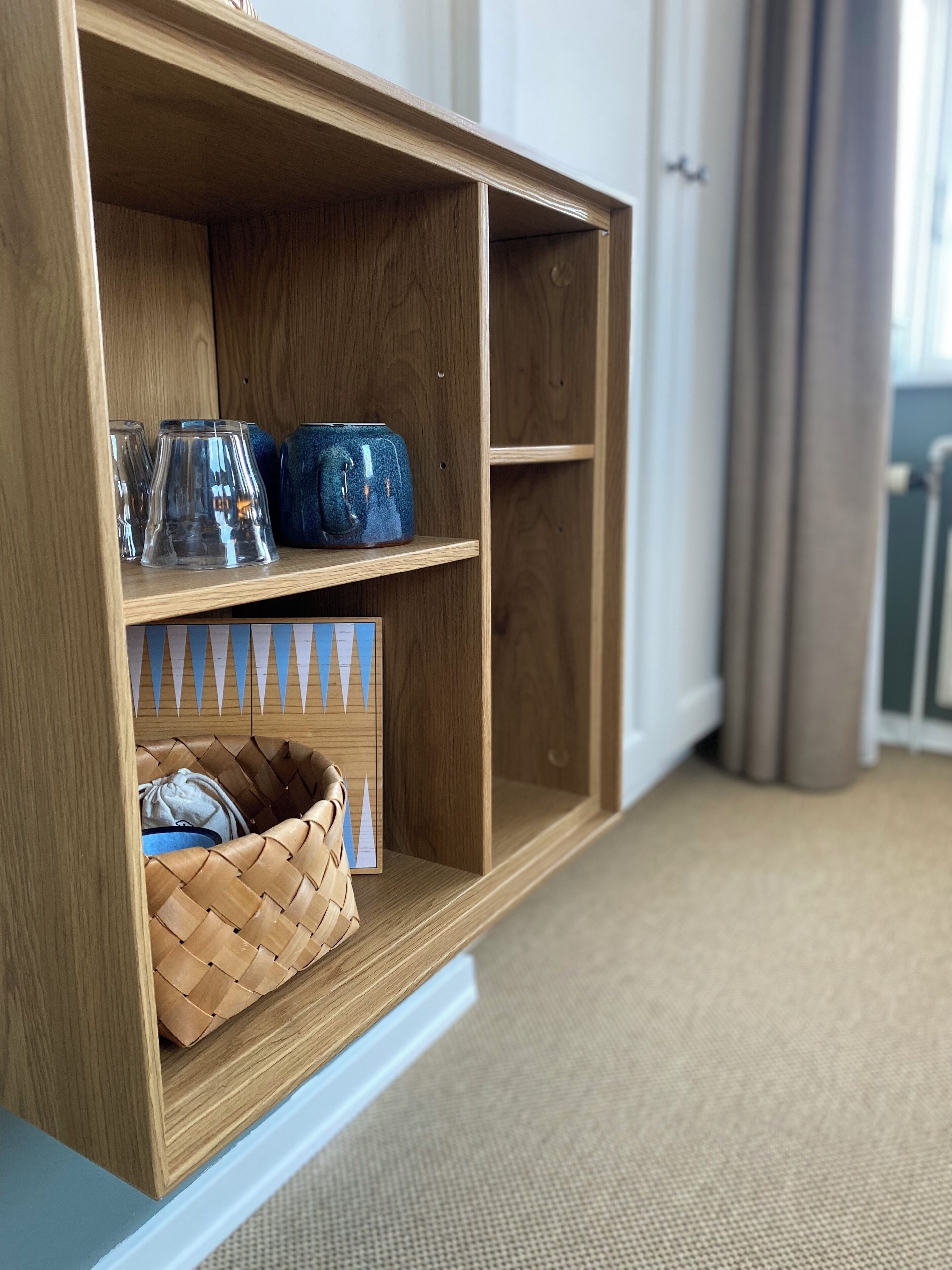 Een houten schapunit met glaswerk en decoratieve objecten.