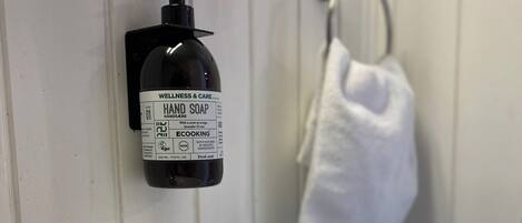 A bathroom sink with a soap dispenser mounted on the wall.