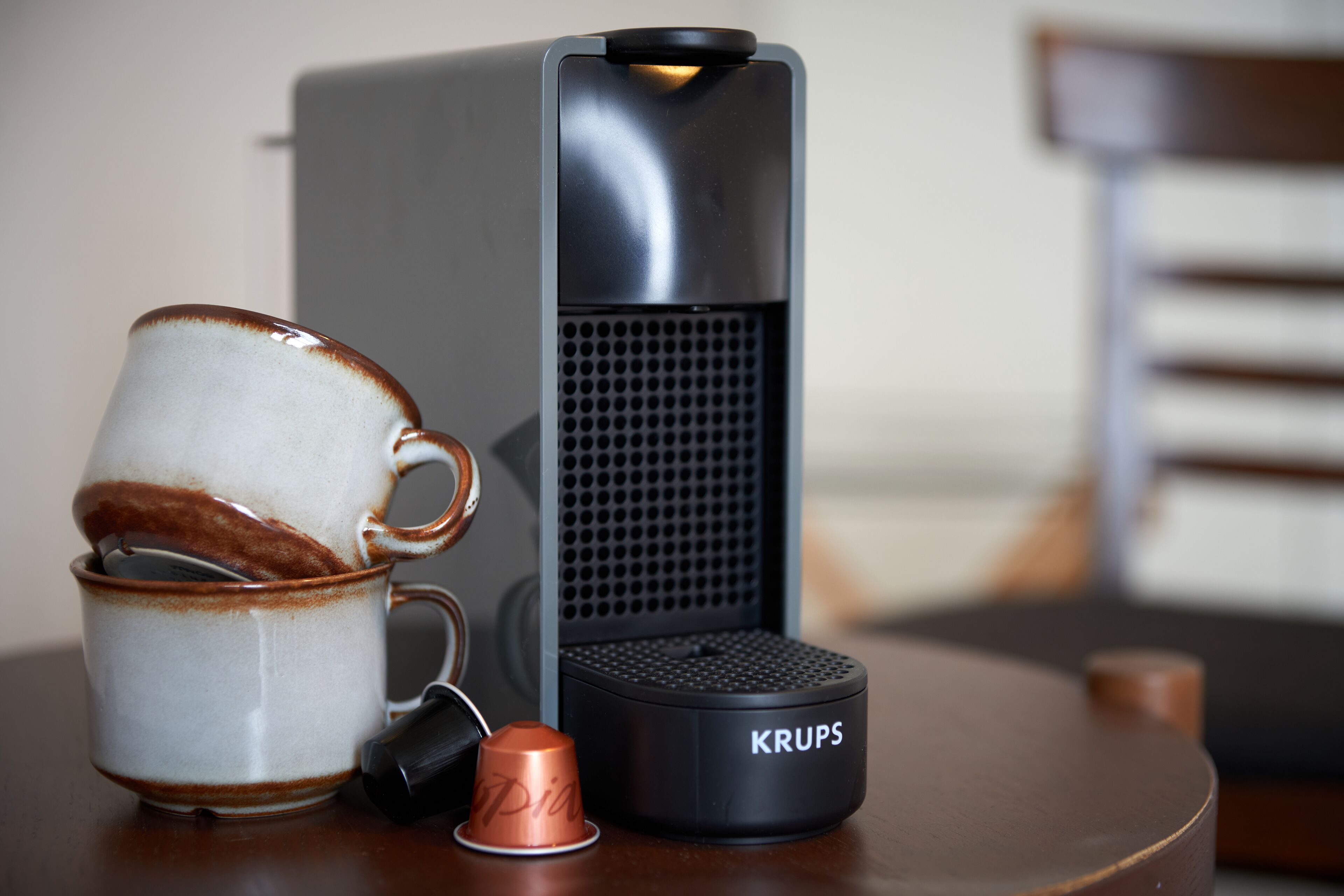 Een koffiezetapparaat, een mok en een thermoskan op een tafel.