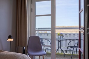 Habitación clásica doble, 1 cama de matrimonio grande, patio, vistas parciales al mar | Zona de estar