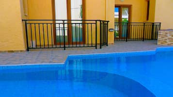 Kolam renang outdoor, dengan payung kolam renang dan kursi berjemur