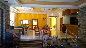 A spacious indoor area with a pool table, multiple seating arrangements, and a staircase leading to an upper level. - Katerini Hotel Apartments (Rethymno)
