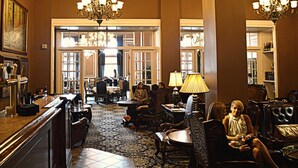 A spacious lobby with high ceilings, ornate chandeliers, and a patterned carpet. - Grant Hall Hotel (Moose Jaw)
