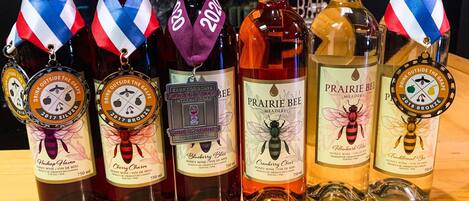 A row of wine bottles with medals on top, each labeled with a different brand and type of wine.